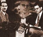 Herman Gamow y Alpher en un fotomontaje de 1949 realizado por el propio Alpher. Se muestra a Gamow saliendo de la botella YLEM (sopa inicial de partículas)